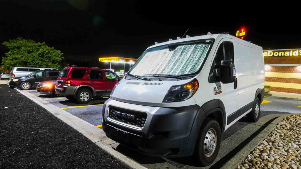 Low-roof 118-inch Ram ProMaster camper van parked at a truck stop